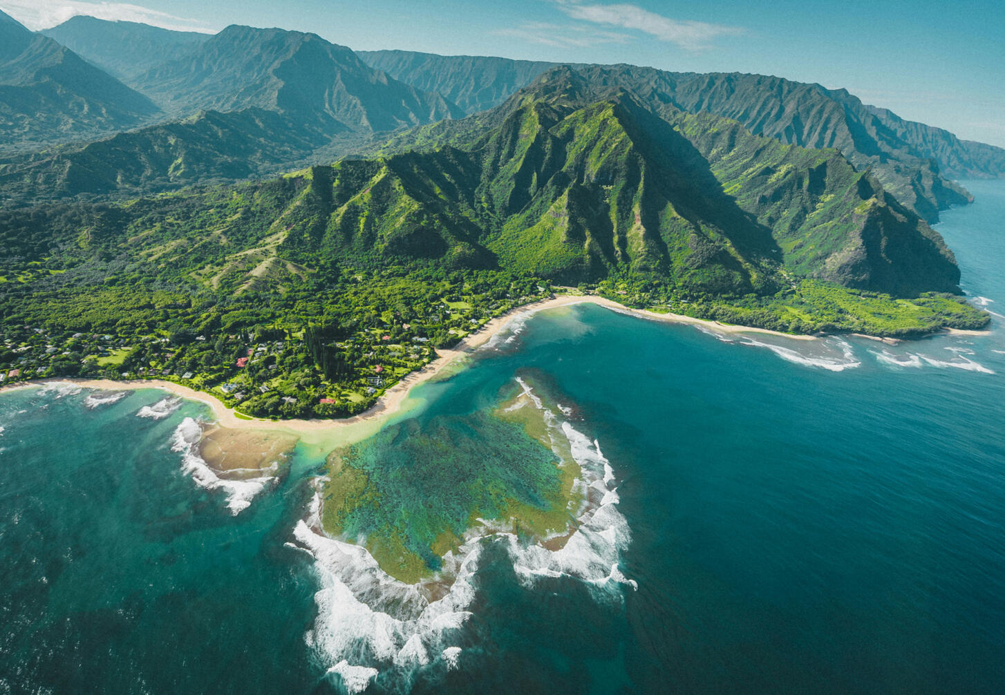 The unique terrain that makes up Hawaii. An aerial shot of the lush mountains, beaches, and sea in Hawaii.