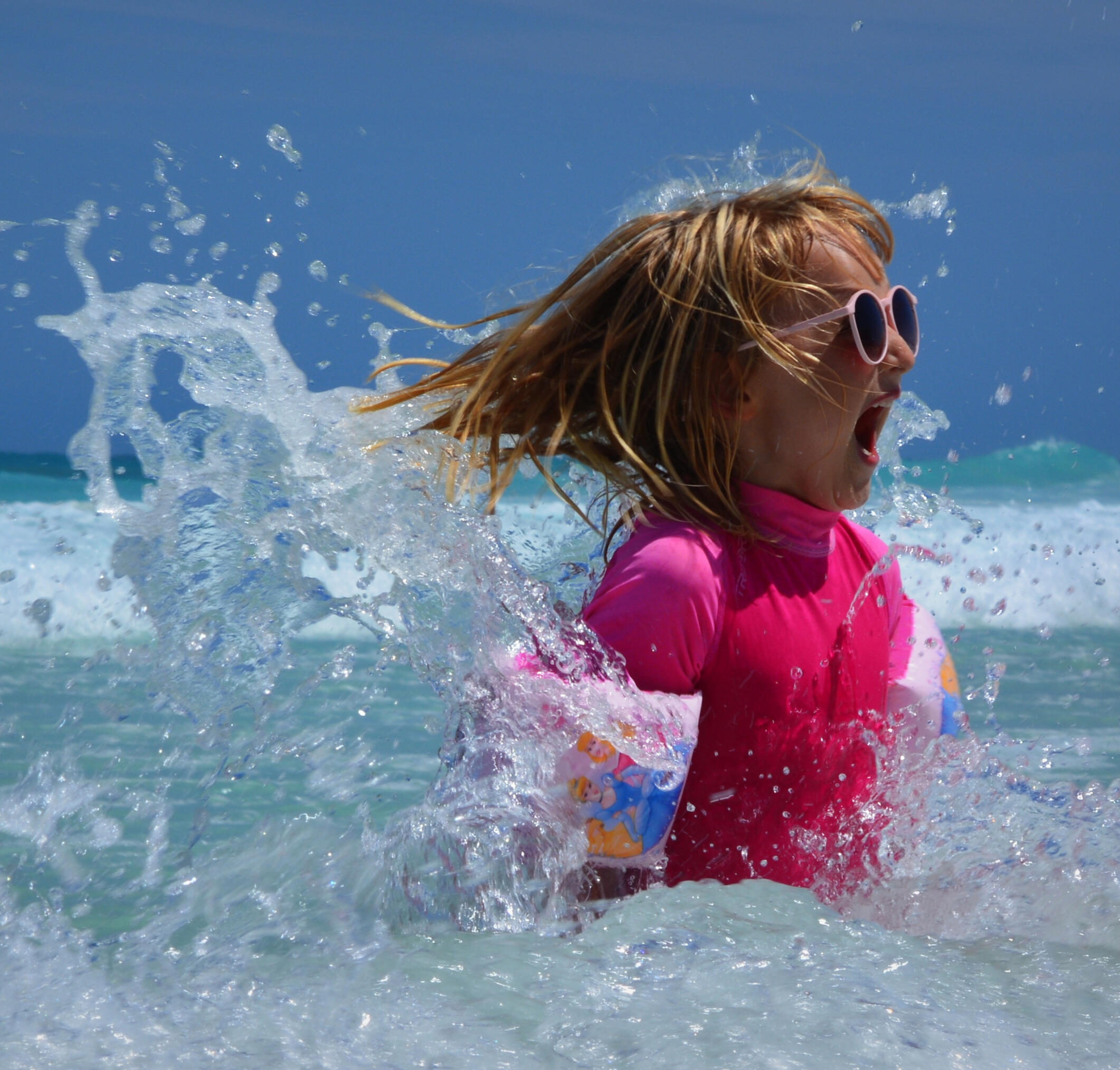 Family ocean vacation Child splashing in the waves at a f Florida beach